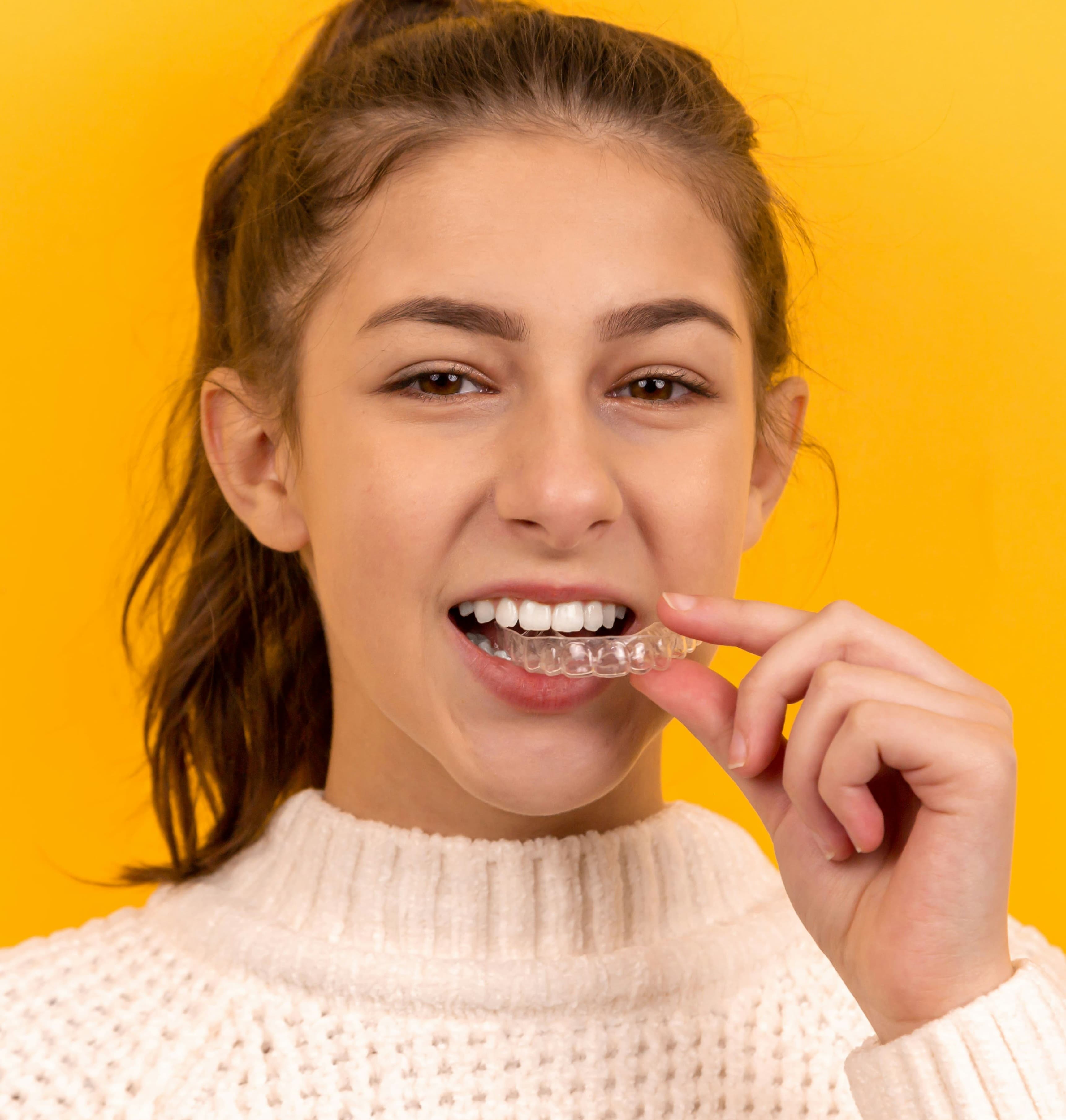 Patient holding a clear Invisalign aligner
